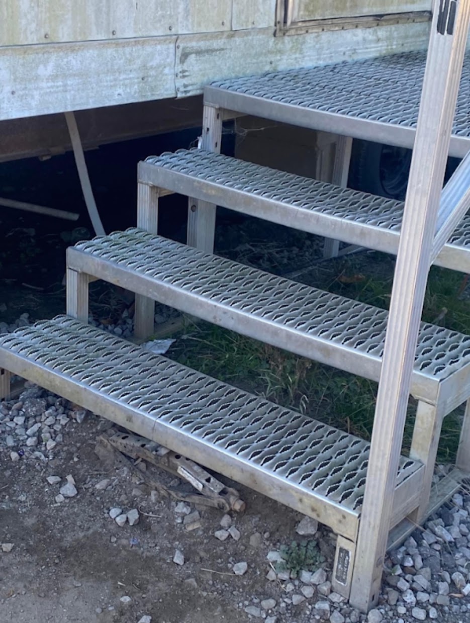 Fabricated metal staircase with expanded grating steps